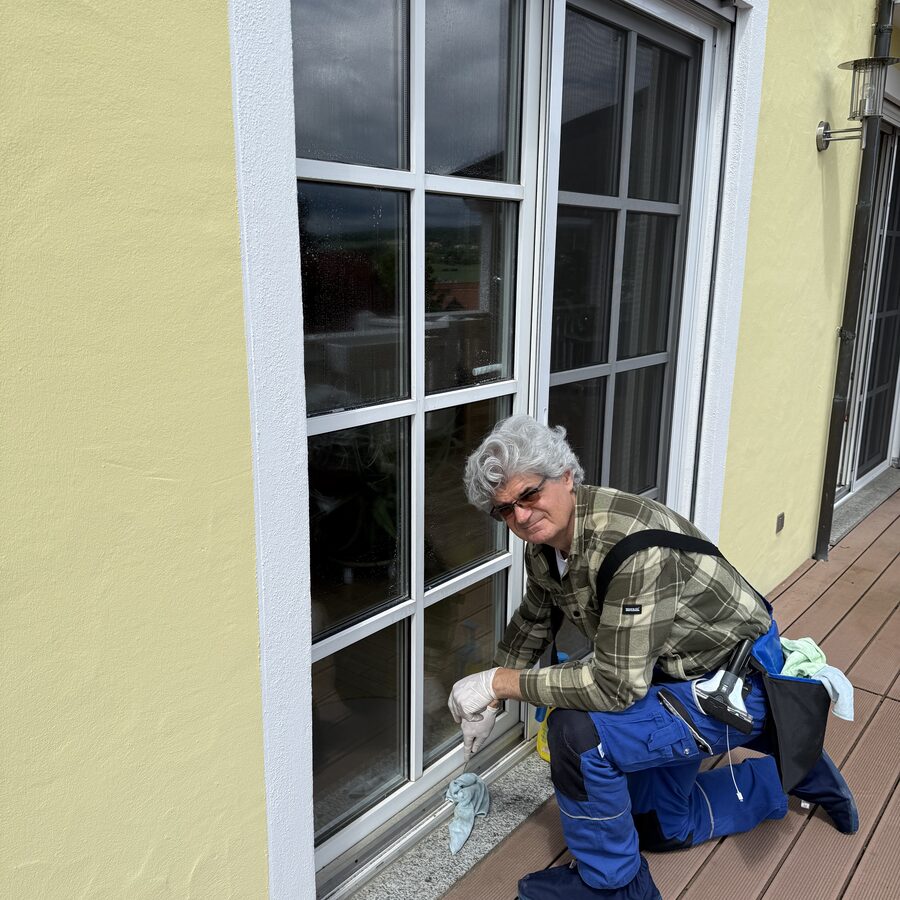 Christof reinigt die Fensterschiene und den Rahmen